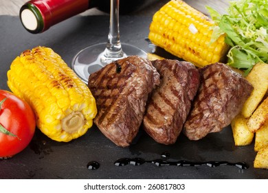 Steak with grilled potato, corn, salad and red wine closeup  - Powered by Shutterstock