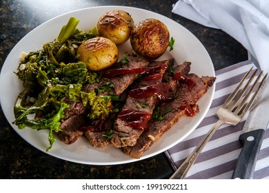 Steak and new potatoes with honey mesquite barbecue sauce and garlicky broccoli rabe - Shutterstock ID 1991902211