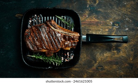 Steak on the bone. Pan-grilled tomahawk steak with rosemary and butter. Top view. - Powered by Shutterstock