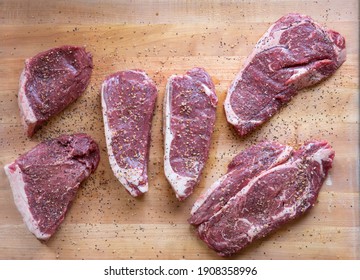 Steak On Butcher Block With Seasoning Various Cuts Of Raw Meat