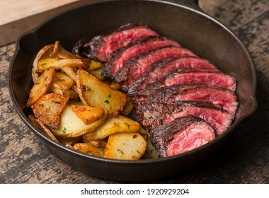 Steak and potatoes. Grade A grass fed angus beef steaks. Tenderloin, filet mignon, New York strip, bone in rib-eye grilled medium rare on outdoor wood-fired grill. Classic American steakhouse entree.