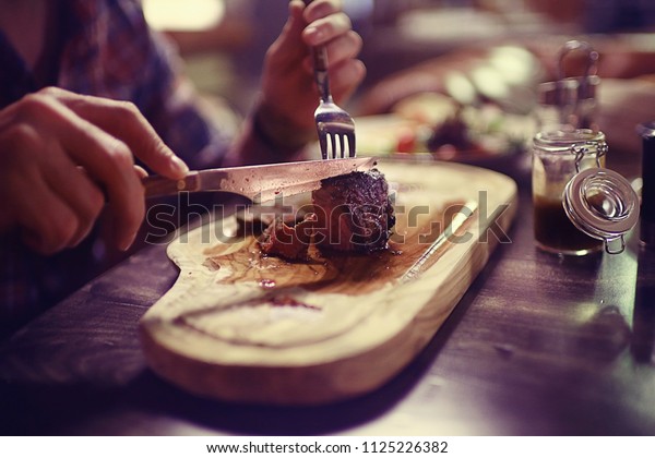 steak in the\
restaurant on the table / dinner in the restaurant, meat on the\
plate, served steak and\
cutlery
