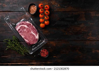 Steak, ribeye, vacuum packing set, on old dark  wooden table background, top view flat lay, with copy space for text - Powered by Shutterstock