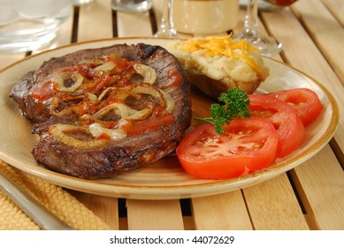 A Steak With Sauteed Onions And Twice Baked Potato