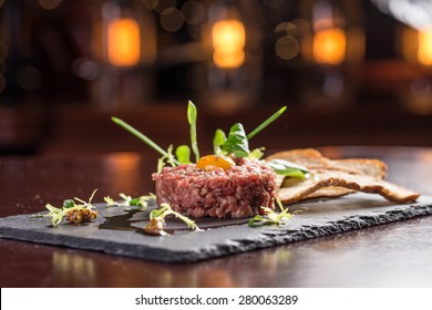 Steak Tartare with bread toasts served on a stone plate