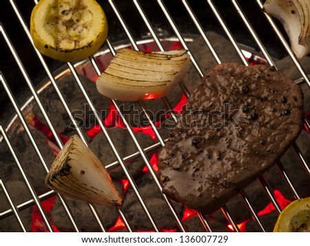 Steak with vegetables cooking on the grill.