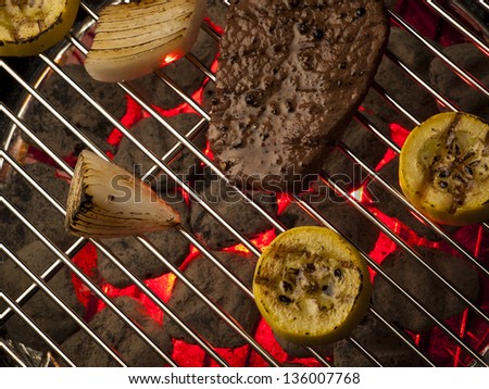 Steak with vegetables cooking on the grill.