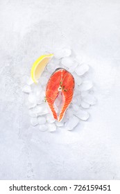 Steaks, fresh red fish on gray background with ice and lemon wedges - Shutterstock ID 726159451