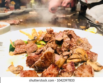 Steaks On The Plate In The Japanese Steakhouse With Chef’s Hands In The Background