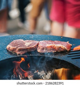 Steaks prepared on bbq grill Close-up, barbecue outdoors with fire flame. Summer picnic concept. Selective focus