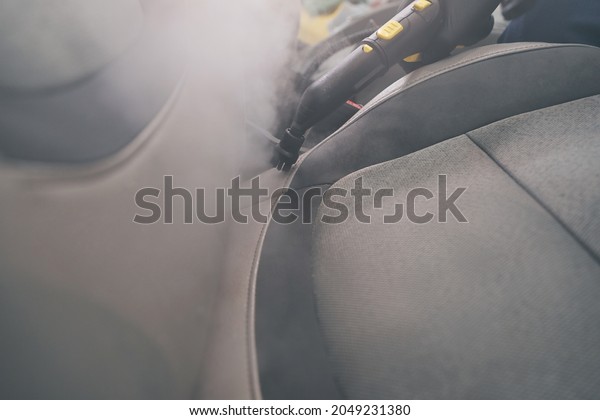 Steam cleaning close-up in auto detailing. Car\
seats wash with steamer