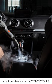 Steam cleaning of gearbox and dashboard in car. Vaping steam. Cleaning individual elements of black leather interior in auto. Creative advert for auto detailing service - Shutterstock ID 2216122217