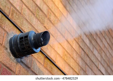 Steam Coming Out Of A Central Heating Flue On A House Wall, England, UK, Western Europe.