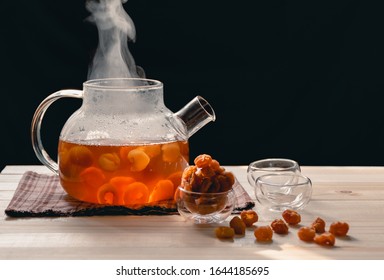 The steam from a cup or pot of tea on the old wood table and black background with nature light by window in the morning, Warm drinks make good healthy, Longan juice has many benefits,Selective focus.