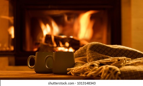 Steam from a cups with a hot cocoa on the fireplace background.  