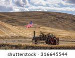 Steam engine and flag in field at the Colfax Threshing Bee in Colfax, Washington.