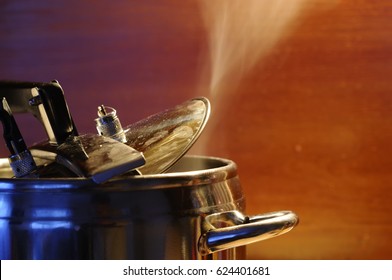 Steam Escaping From Lid Of Pressure Cooker With Reflection Of Modern Kitchen. Indian Style Cooking Rice Or Dhal