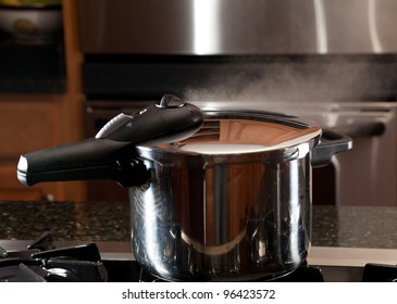 Steam Escaping From Lid Of Pressure Cooker With Reflection Of Modern Kitchen