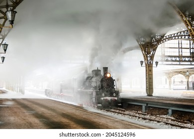 Steam locomotive stands on the platform of the station, winter cold snowy day - Powered by Shutterstock