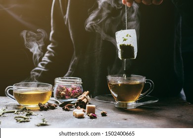 The steam from man with jecket Jean is soaking tea bag on vintage white cup, preparing hot tea.Dipping teabag on cup,hot food and healthy meal concept - Powered by Shutterstock