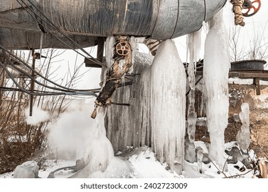 Steam metal pipe leaks water. Pipe burst in winter. Frozen water from steam pipes in winter close up. Huge steam pipes of the central boiler plant. - Powered by Shutterstock