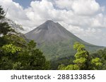 Steam rises from Arenal volcano in Cost Rica is framed by the beautiful tropical rain forest of La Fortuna.  Arenal is one of seven major volcanos in the country. 