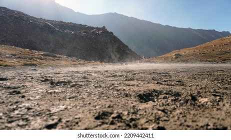 Steam rises from the ground in the mountains. The place resembles a volcano. Steep cliffs and cliffs. There is yellow grass on the slopes. Various traces are visible. The sun is shining brightly - Powered by Shutterstock