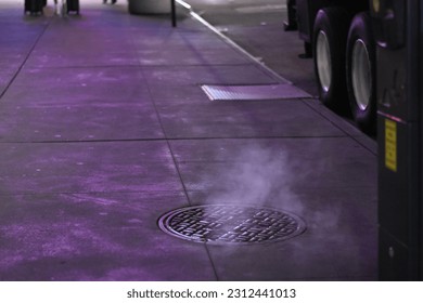 Steam Rising from a Manhole Cover on Sidewalk in New York City 