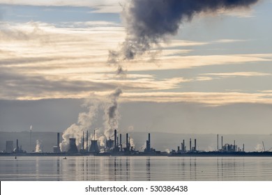 Steam and smoke emissions from the petrochemical plant at Grangemouth in Scotland on a still day in winter.