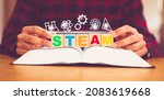 STEAM or STEM. Science, technology, engineering, art, mathematics icon. Education on teenager kid hand with "STEAM" on wooden block.Education innovation for student at school and homeschool.curriculum