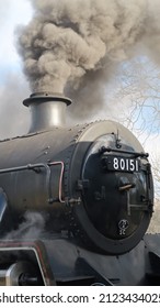 Steam Train With Smoke Billowing Smoke From Its Stack.