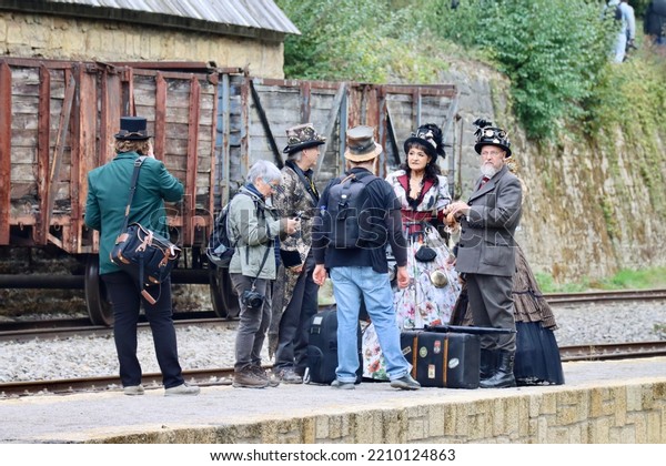 Steam train station, group of Steampunk convention\
visitors on platform next to freight wagons. Fond-de-Gras,\
Luxembourg - September 25,\
2022
