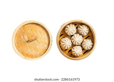 Steamed baozi dumplings stuffed with meat in a bamboo steamer. Isolated on white background
