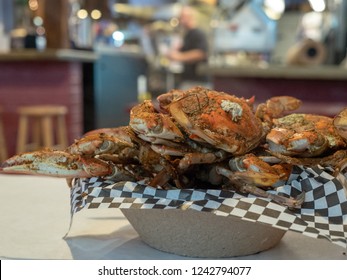 Steamed Chesapeake Bay Blue Crabs Covered In Seasoning Sitting In Paper Bowl On Paper Covered Table