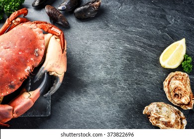 Steamed crab and fresh oysters on dark background. Sea food dinner concept 