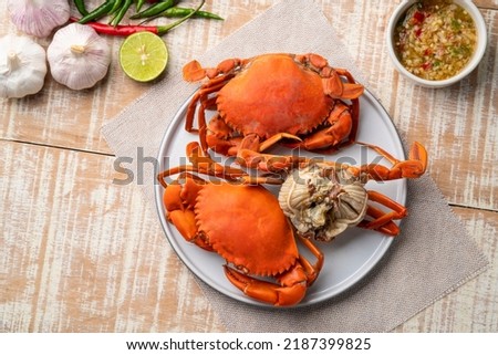 Steamed Crab,Boiled Serrated mud crab in a plate with seafood sauce.Top view