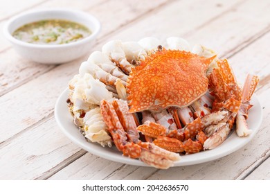 steamed crabs with spicy dipping sauce in white ceramic plate on white old wood texture background, blue swimming crab, flower crab, blue crab