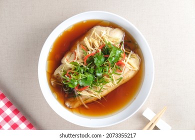 Steamed Dory fillet fish with spicy soy sauce and ginger served on white plate. Chinese food style. - Shutterstock ID 2073355217