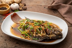Steamed Fish With Ginger, Scallion And Soy Sauce In White Plate.(Pla Neung See Ew)