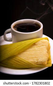 Steamed fresh corn cake in a leaf, called "Humita", is a traditional and popular Ecuadorian dish. Accompanied by a cup of hot black coffee.