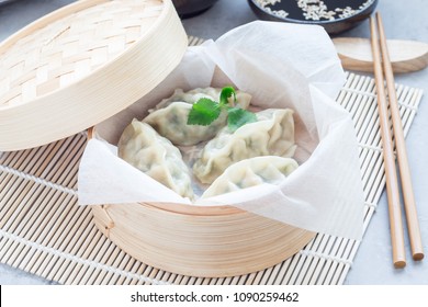 Steamed Korean dumplings Mandu with chicken meat and vegetables in a bamboo steamer, horizontal