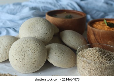 Steamed Little millet cakes or little millet idli. Made with a fermented batter of little millet, lentils. Served with coconut chutney. Shot with little millet in a wooden bowl