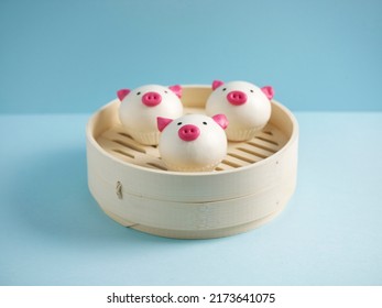 Steamed Molten Salted Egg Yolk Custard Piggy Bun Served In A Wooden Bowl With Chopsticks Isolated On Mat Side View On Grey Marble Background