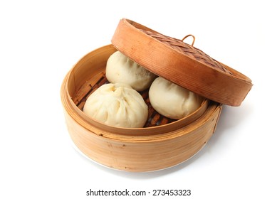 steamed pork buns, chinese dim sum in the bamboo steamer isolated on white