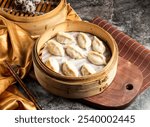 Steamed shrimp dumplings served in bamboo steamer isolated on wooden board side view of taiwan food