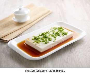 Steamed Spring Water Tofu in Supreme Soya Sauce with chopsticks served in a dish isolated on mat side view on grey background
