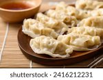 Steamed wonton dumpling stuffed with minced pork and chicken eating with sesame oil sauce