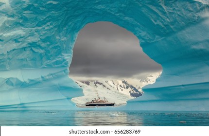 Steamer ship seen through the hole in the iceberg at Antarctic peninsula - Shutterstock ID 656283769
