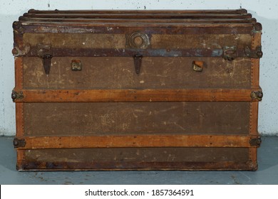 Steamer Trunk From The 1940s Photographed On A Grey Painted Floor And In Front Of A White Concrete Wall.