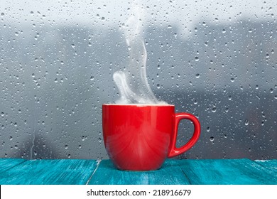 Steaming Coffee Cup On A Rainy Day Window Background